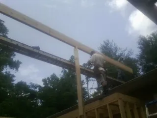 Carpenter setting a ridge beam over a new addition frame — Ice Dam Removal by Roofing Brothers in Toccoa