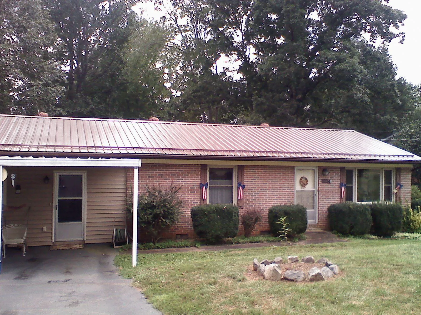 Bronze metal roof and carport on a brick ranch home — Roof Repair work by our crew in Toccoa